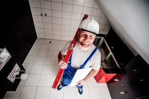 Construction Workers wearing a hardhat, holding a measuring device and documenting a companies workplace safety program. 